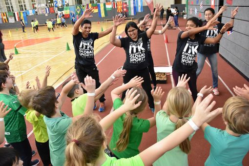 Das Bild zeigt ITK-Trainer:innen bei einem Sportfest mit Kindern in einer Sporthalle. 